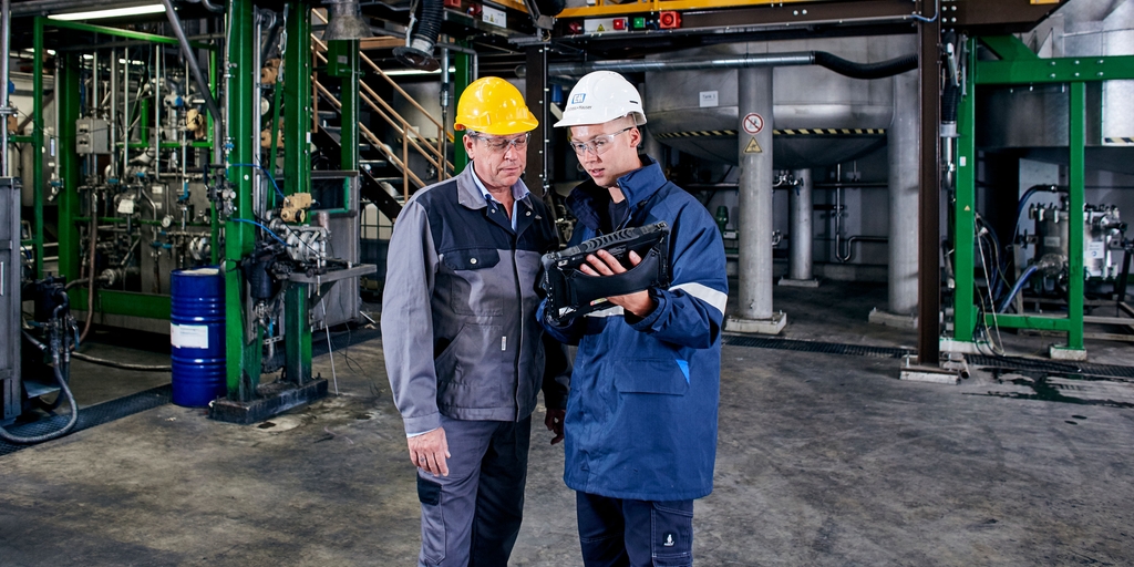 Empleado de Endress+Hauser con un cliente en la planta agroquímica utilizando el Field Xpert Empleado de Endress+Hauser con un cliente en la planta agroquímica utilizando el Field Xpert