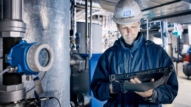 Transmisor de temperatura iTEMP TMT142B junto a un empleado de Endress+Hauser sobre el terreno
